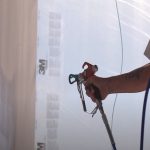 Commercial painter spray painting with an electric spray gun