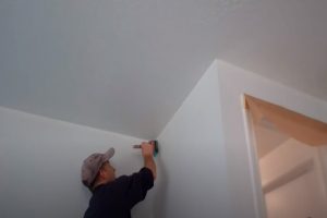 Worker painting interior wall of a home